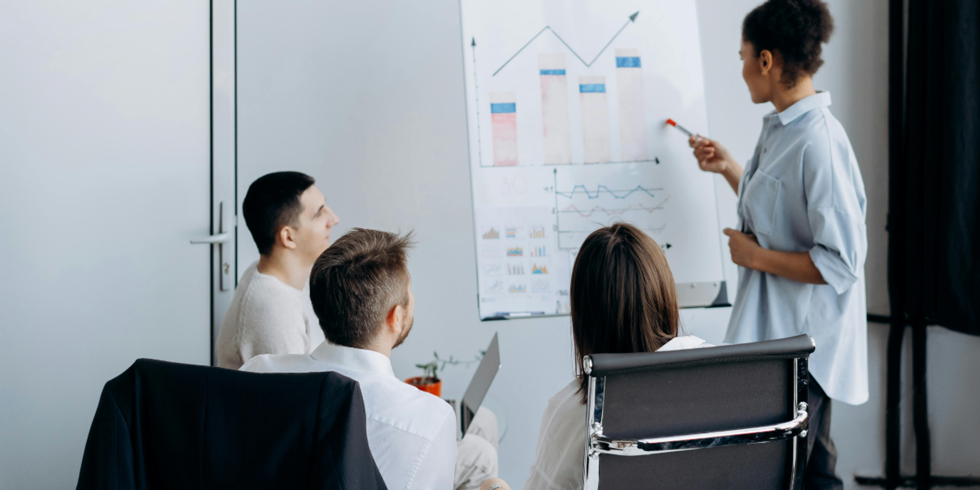 Colleagues enjoying improved meeting productivity while a female worker analyzes sales performance