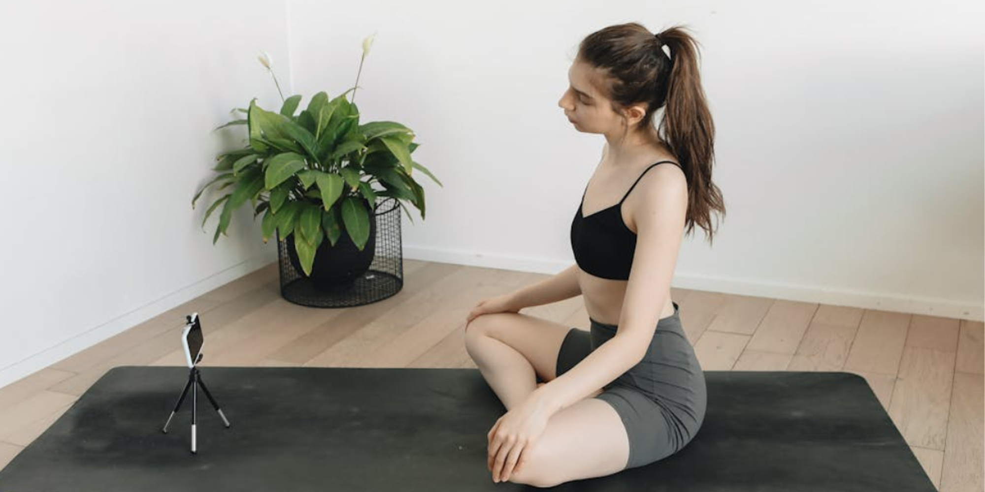 Female on yoga mat using streaming equipment