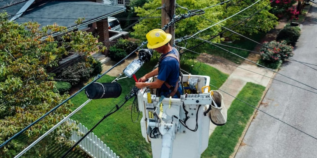 Electrician fixing distribution lines in yellow hard hat illustrating local marketing strategies for electricians