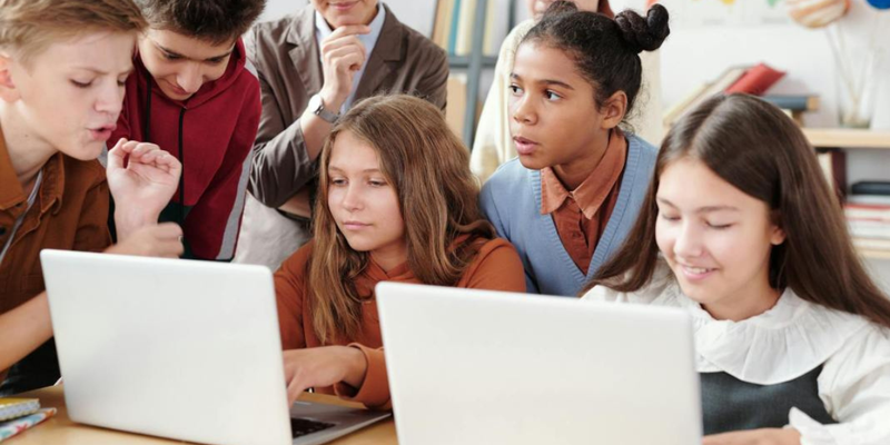 elementary school kids by laptops trying collaborative learning tools