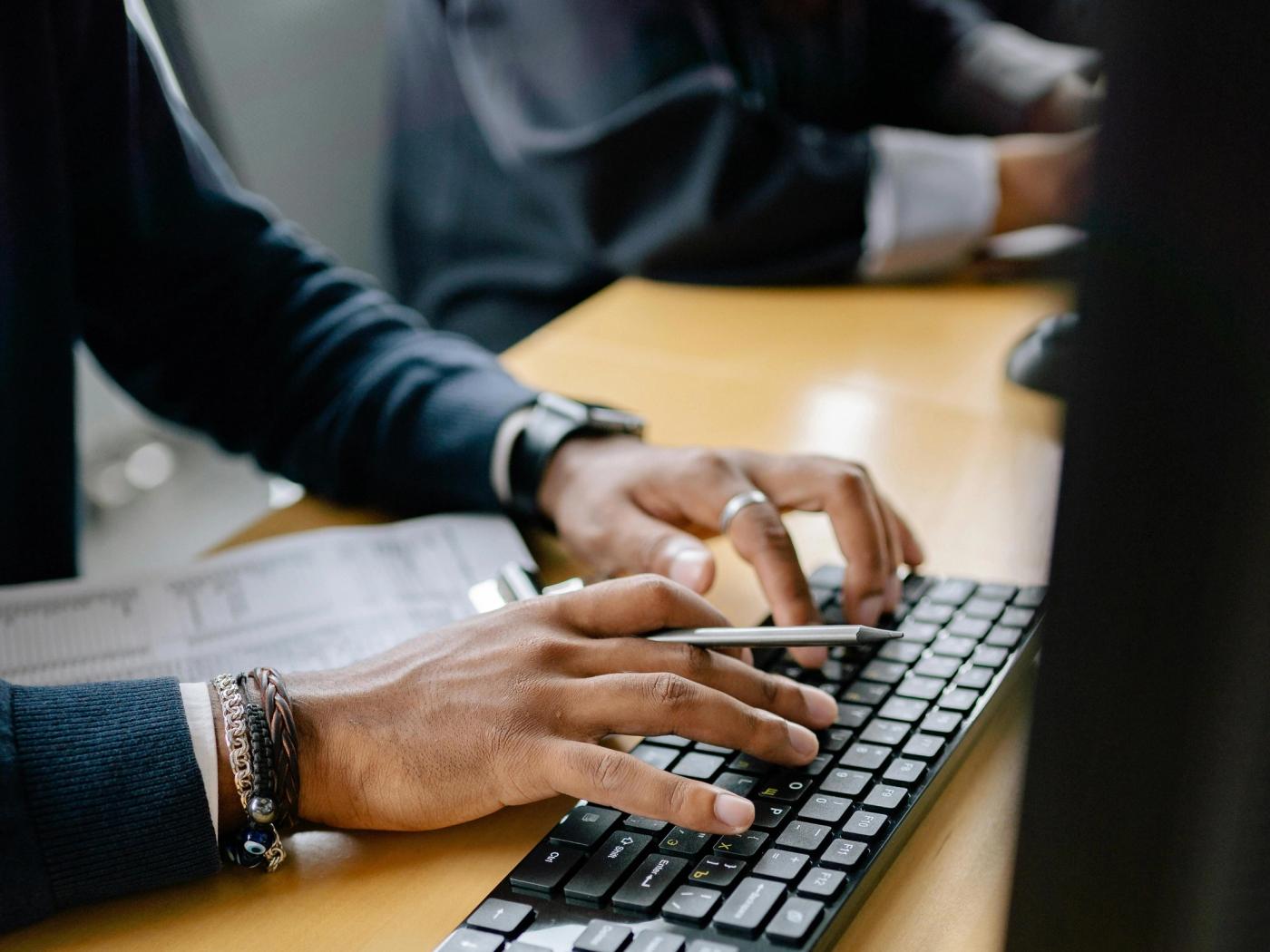 Person typing on a computer while using a school administration software and student management platform