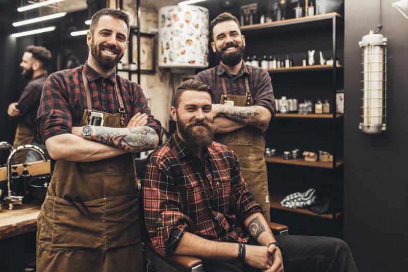 three smiling barbers in plaid shirts knowing how do you promote a barber shop