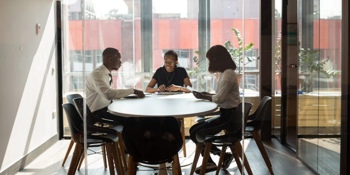 tres personas elegantes están hablando sobre el proceso de reserva de salas de reuniones