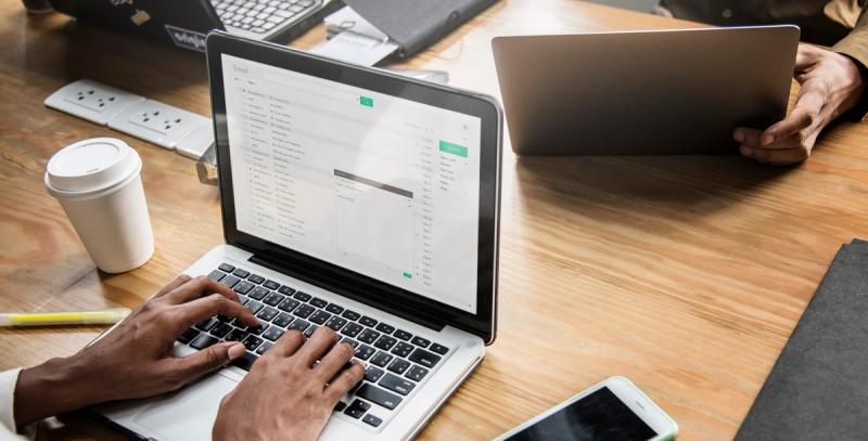 Professionals typing a meeting recap email template after a conversation, organizing next steps and scheduling follow-ups.