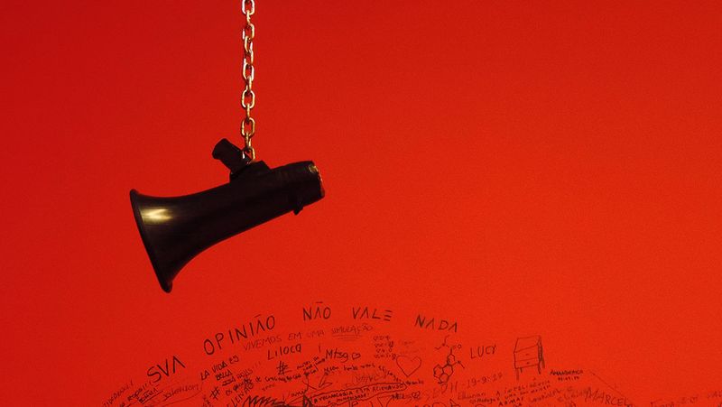 A megaphone hanging against a red wall