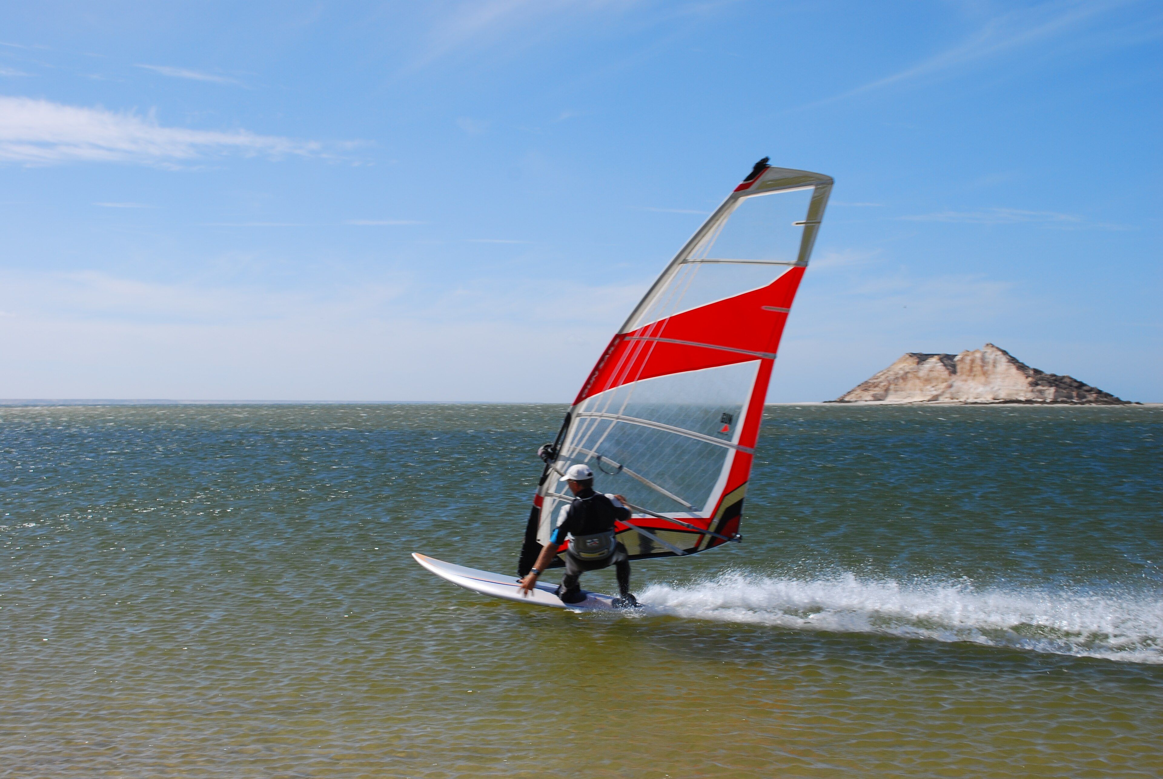 A windsurfer crossing the Dakhla lagoon in front of Dragon Island
