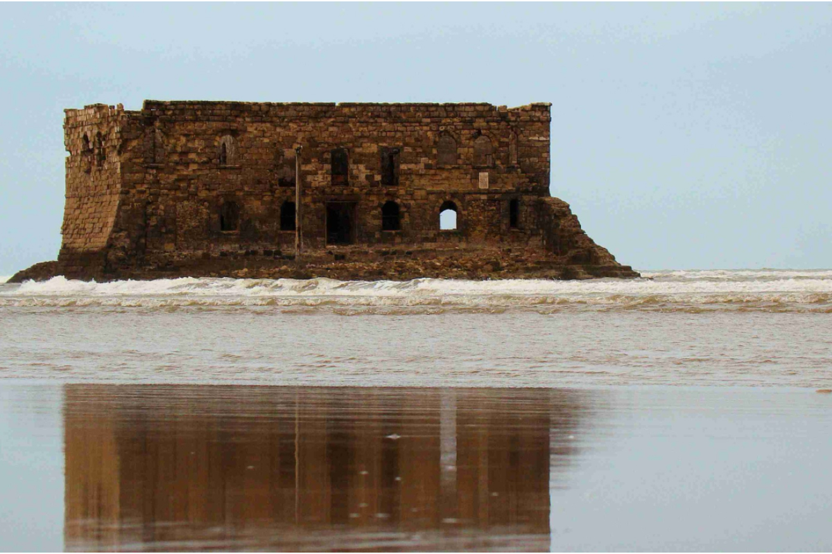 Casa Mar standing in the sea off Tarfaya, reflected in the wet sand