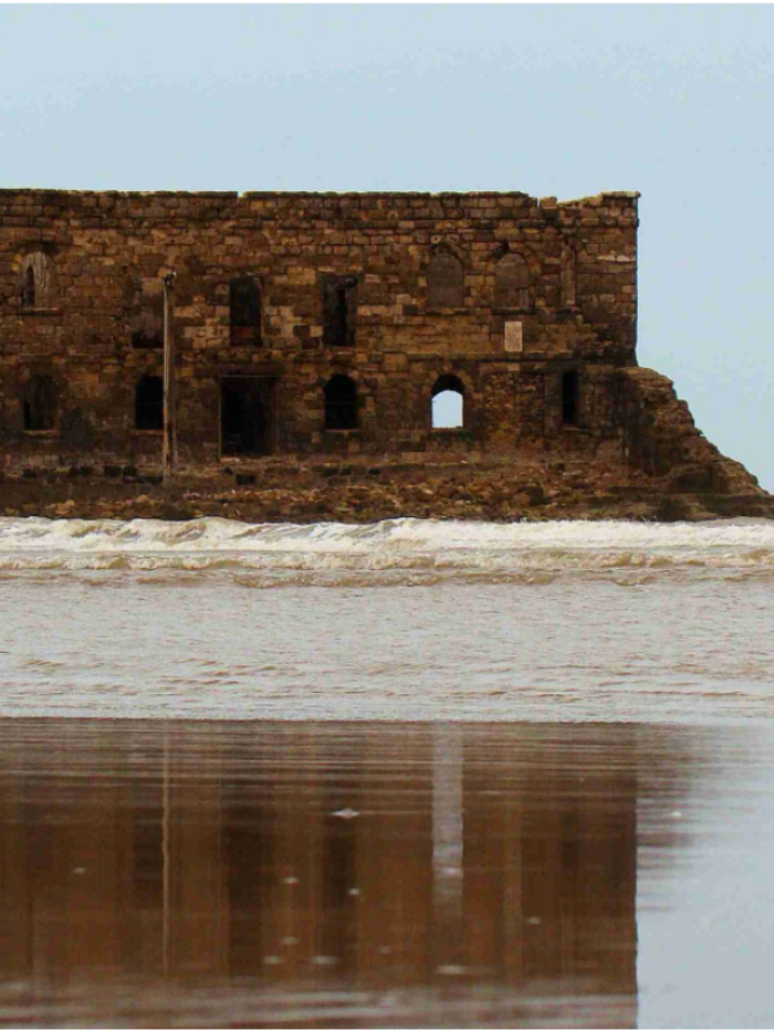 Casa Mar standing in the sea off Tarfaya, reflected in the wet sand