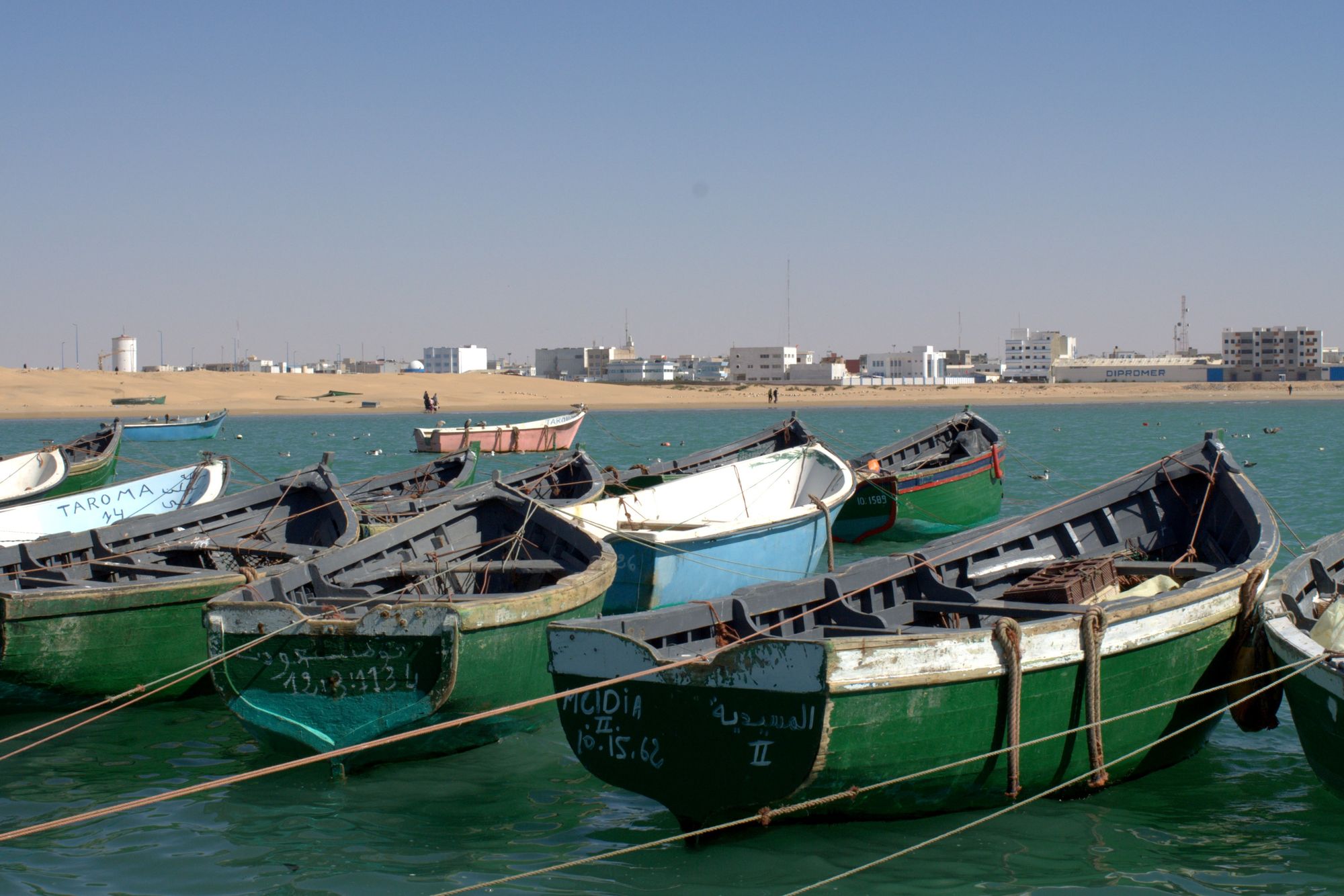 Painted wooden fishing boats moored in the harbour at Laâyoune