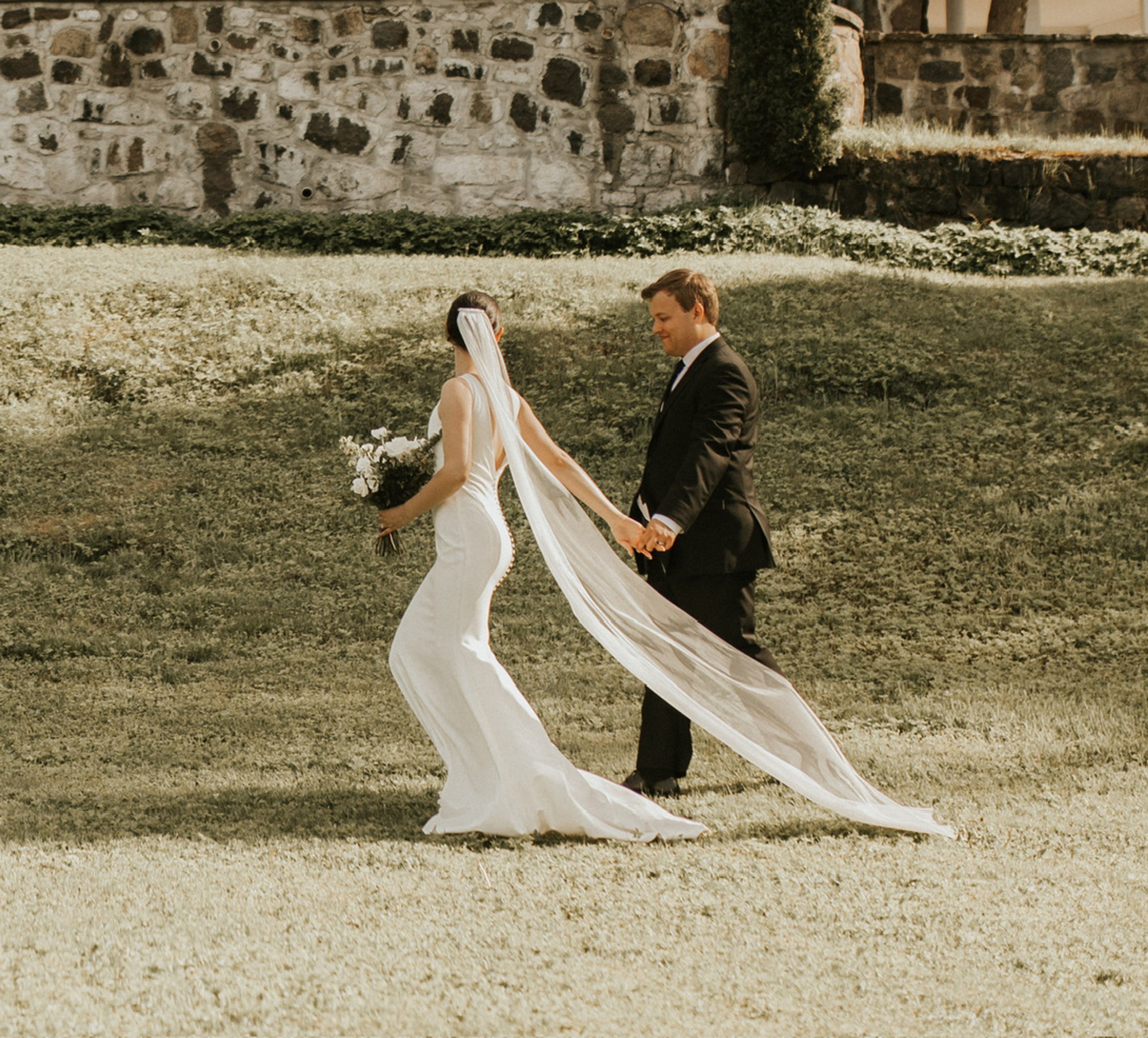 Un couple de mariés qui marche vers un manoir Belvoir