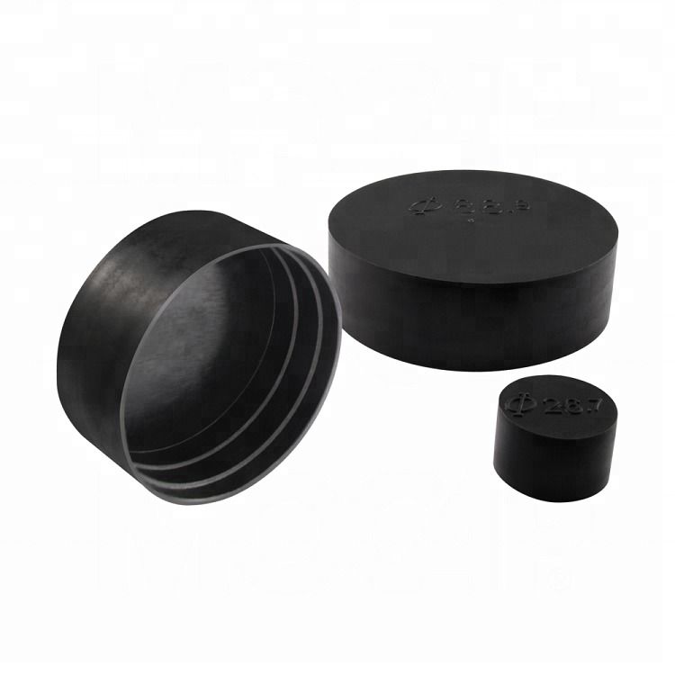 Assortimento di tappi per tubi e cappucci terminali in silicone, vinile e HDPE in varie dimensioni, disposti con calibri digitali accanto a un tubo metallico