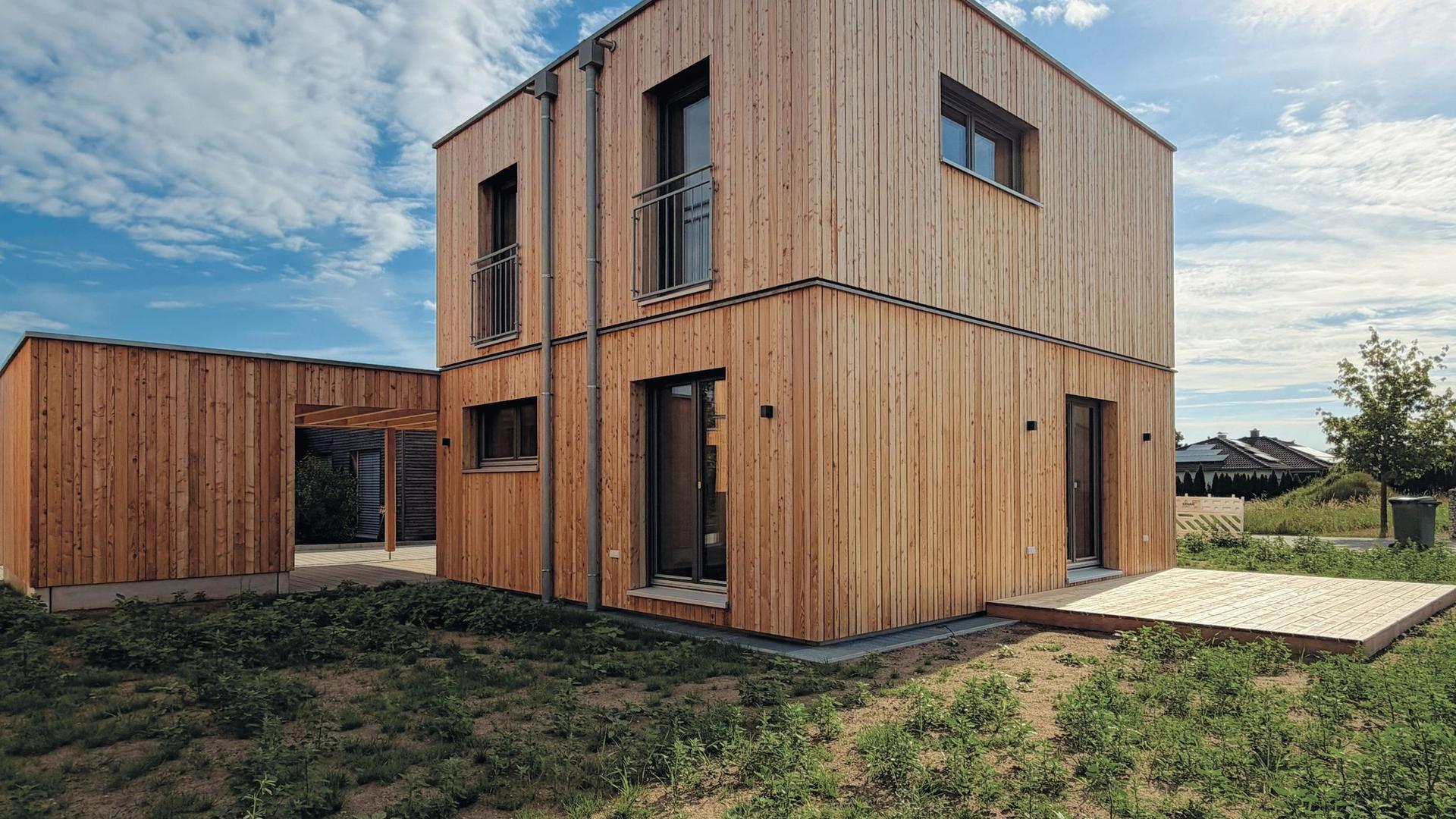 Modulhaus mit französischen Balkonen und Holzterrasse im Abendlicht