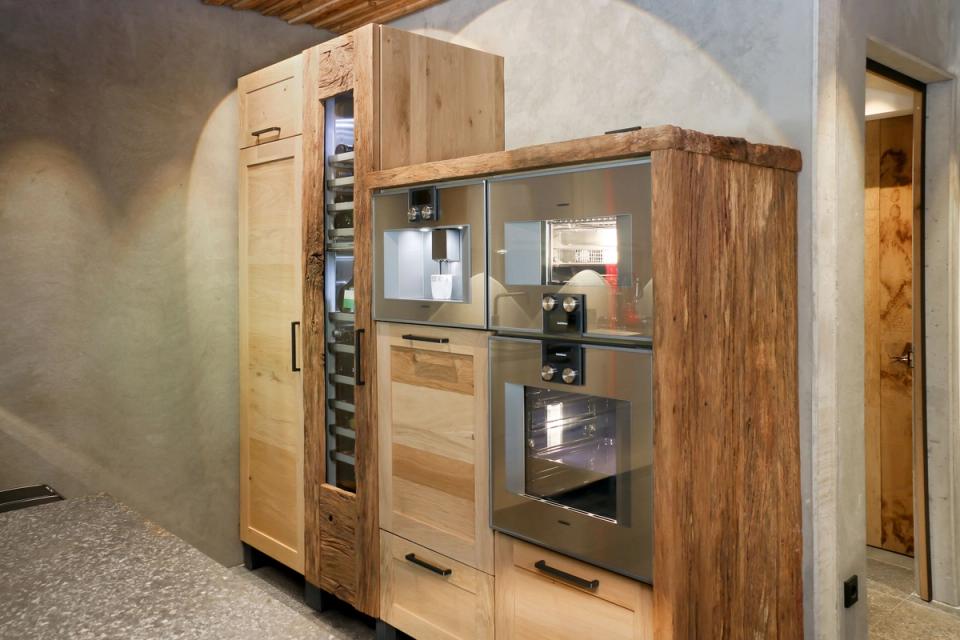 Küchenzeile aus Altholz mit Einbaugeräten und Weinschrank im Eventkeller