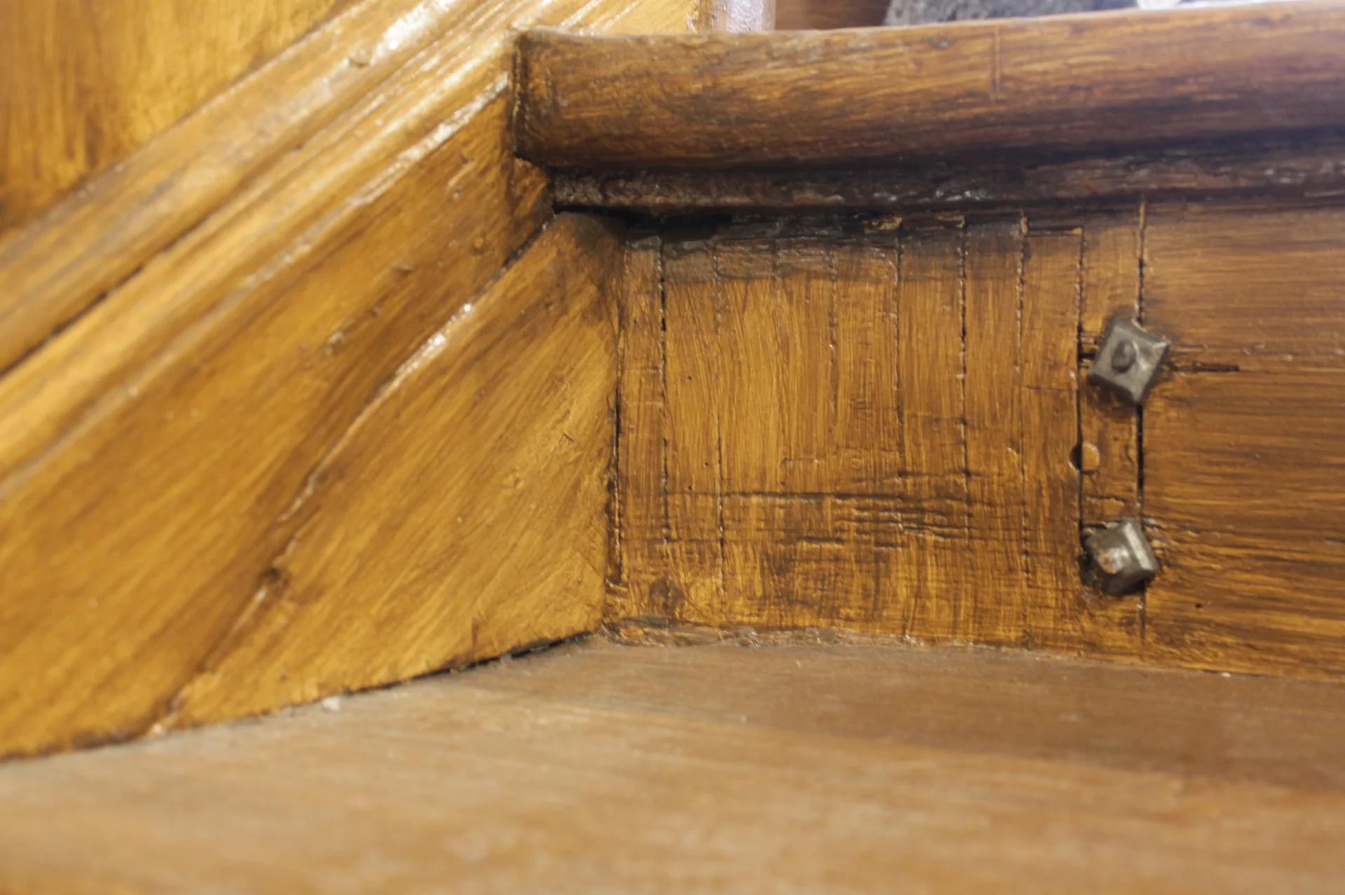 Nahaufnahme einer gestrichenen Holzverbindung mit sichtbaren Beschlägen