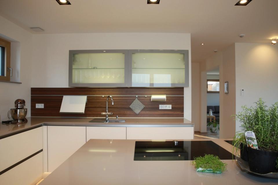 Moderne Küche, weiße Fronten, Nussbaum-Rückwand, Glasoberschränke