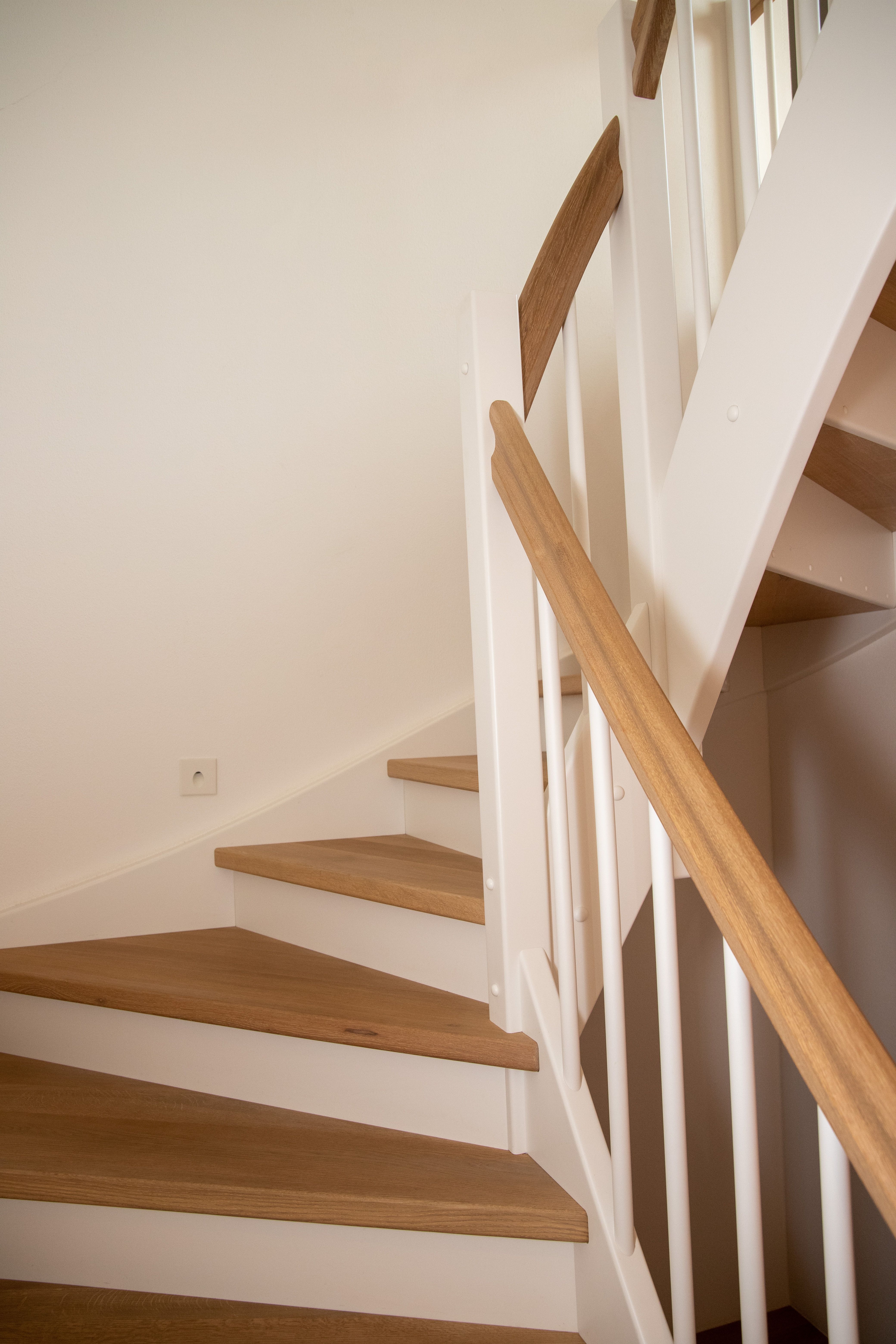 Treppe mit Eichenstufen, weißen Wangen und Eichenhandlauf