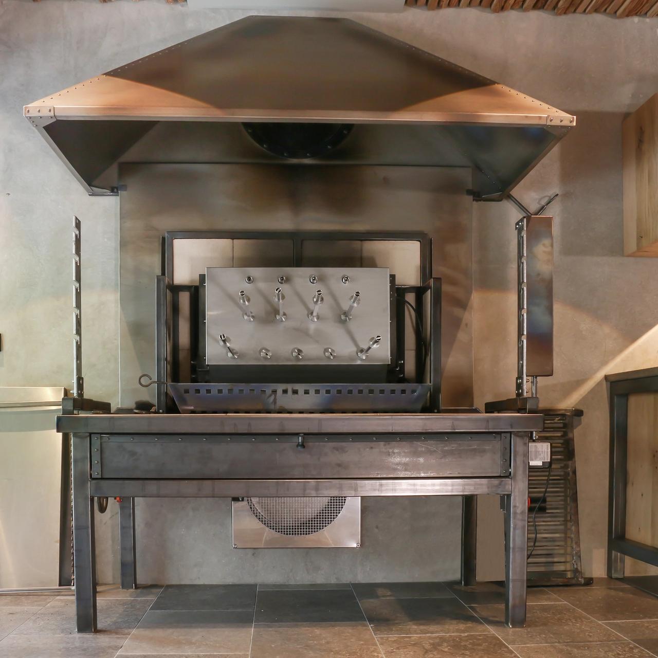 Indoor-Grillstation aus Stahl mit großer Abzugshaube im Eventkeller