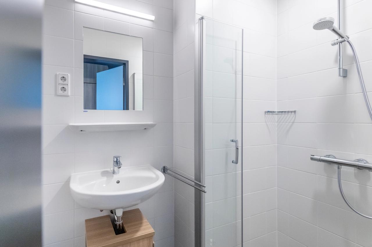 Weiß gefliestes Bad mit Dusche im Unterkunftsgebäude