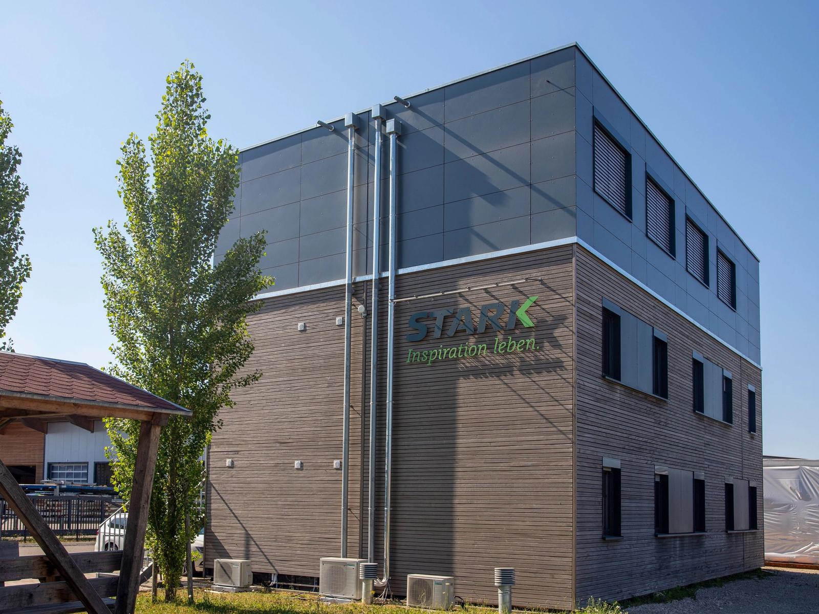Aufgestocktes Bürogebäude der Zimmerei Stark mit Holzfassade und dunklem Plattengeschoss