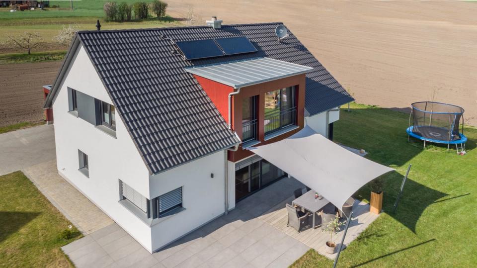 Luftaufnahme von Haus mit Terrasse, Sonnensegel und Feldern