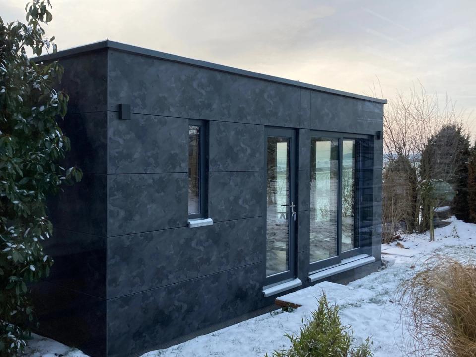 Saunamodul Zweiflingen — Freistehende Gartensauna, dunkle Fassadenplatten im Schnee