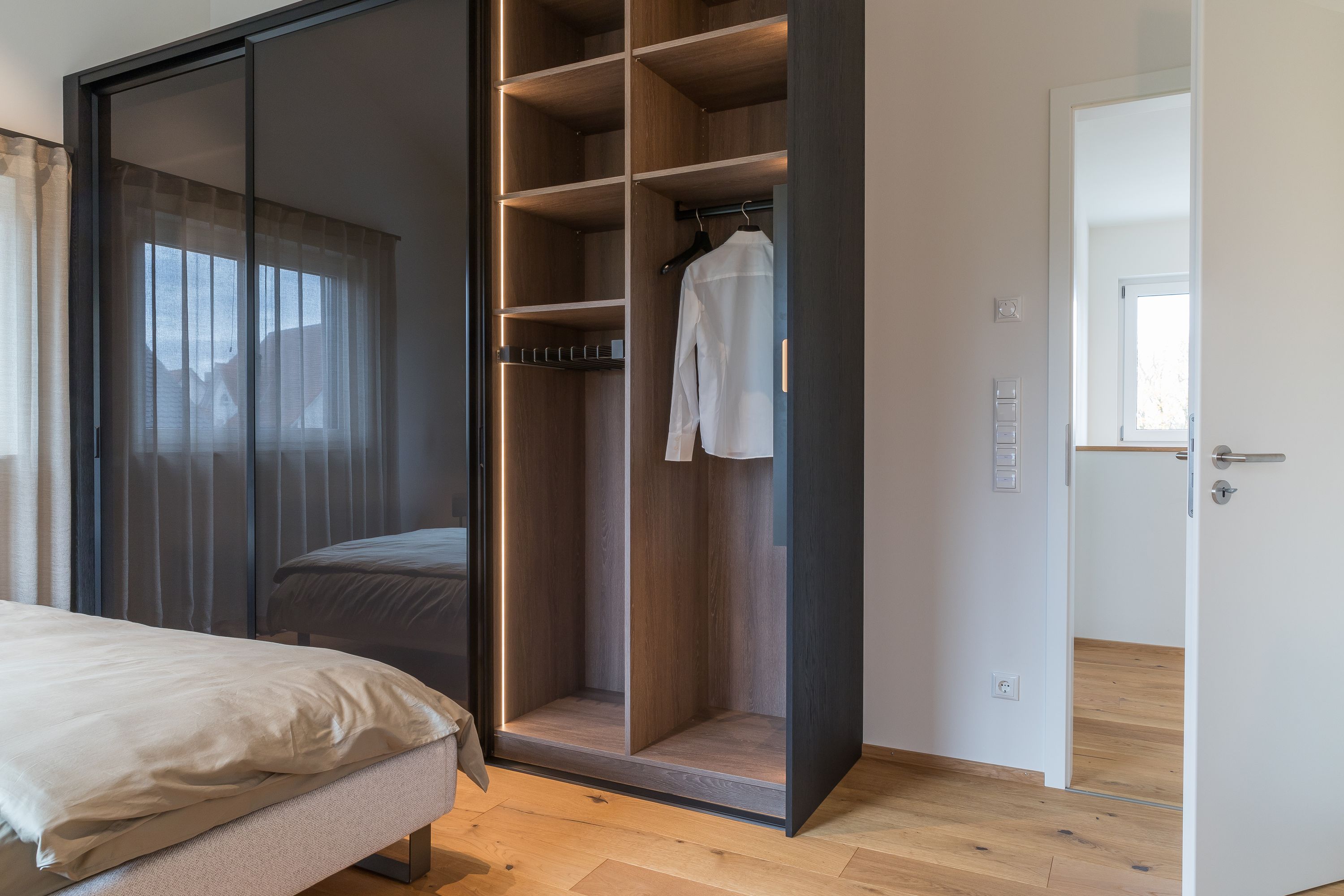 Kleiderschrank mit offener Glas-Schiebetür, Innenbeleuchtung und Kleiderstange