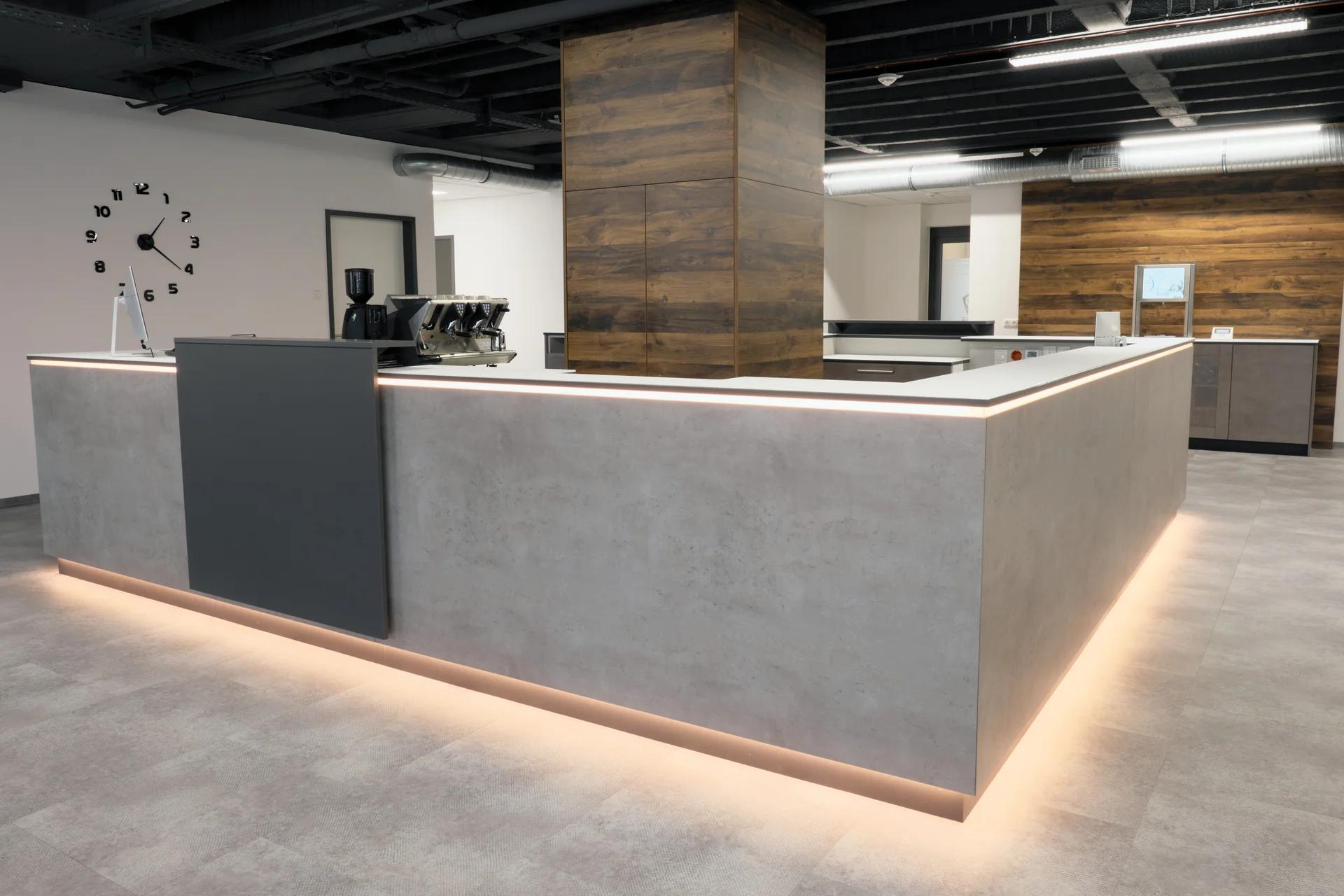Empfangstheke des Fitnessstudios team99 in Beton-Optik mit LED-Beleuchtung