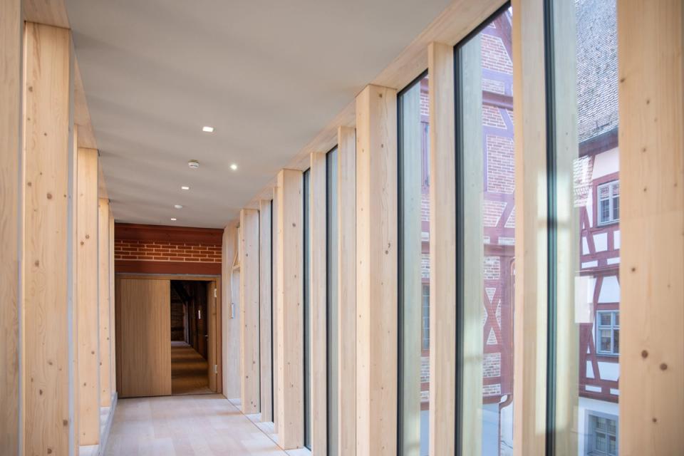 Flur im Hotelneubau mit Holzstützen und Blick auf Fachwerkfassade