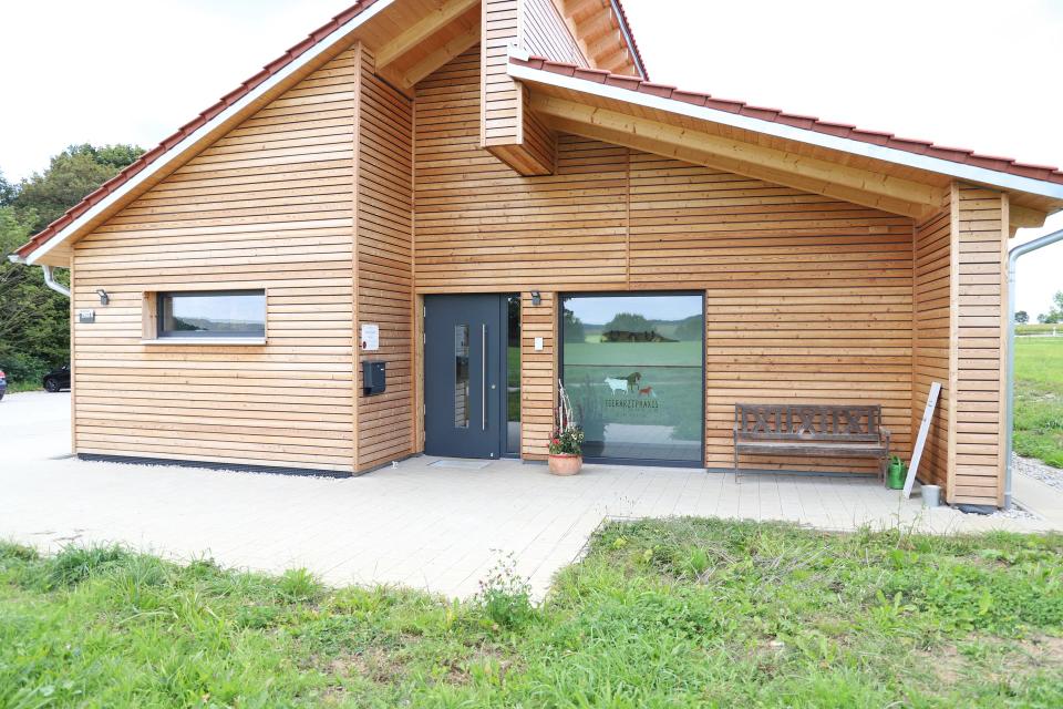 Eingang der Tierarztpraxis mit Holzfassade und Glasfront