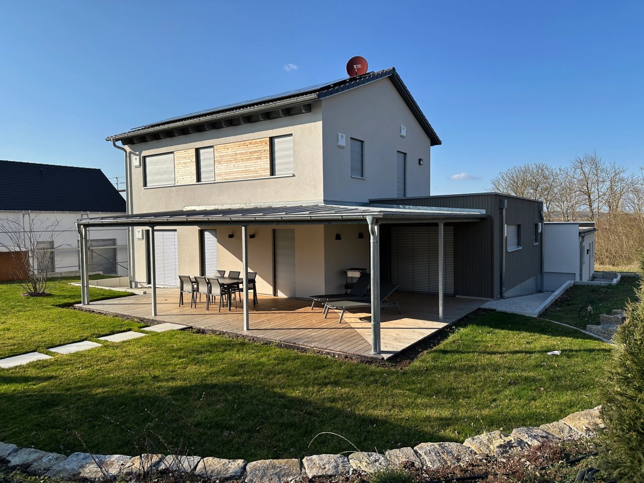 Musterhaus mit Terrassenüberdachung und Gartenweg aus Trittplatten