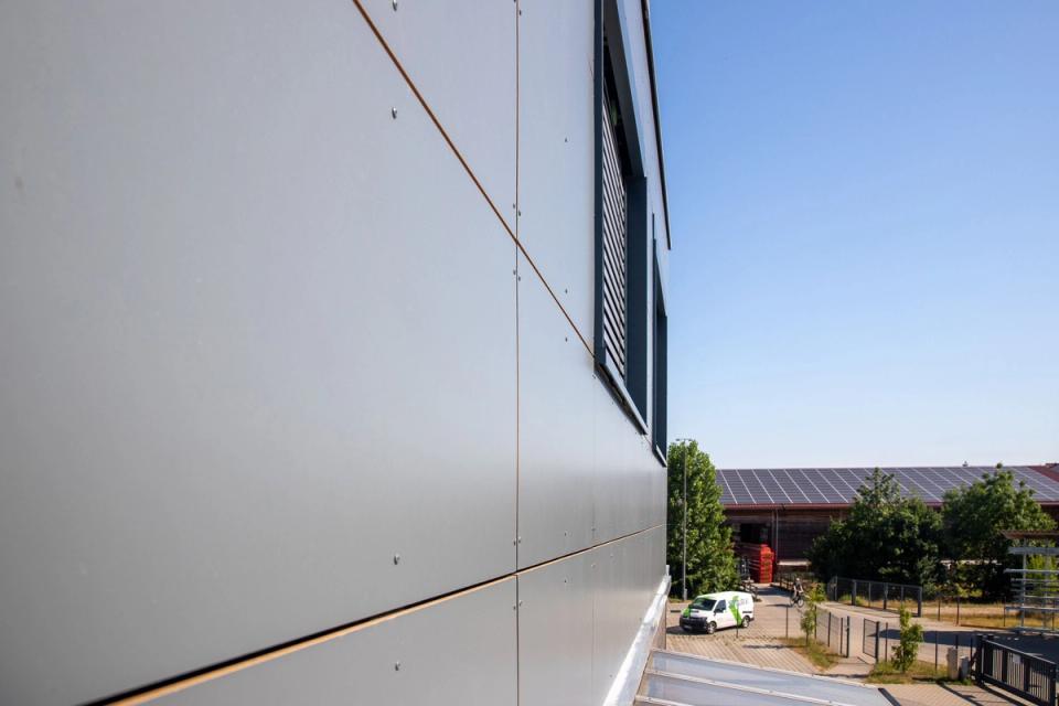 Blick entlang der Plattenfassade der Aufstockung auf den Betriebshof
