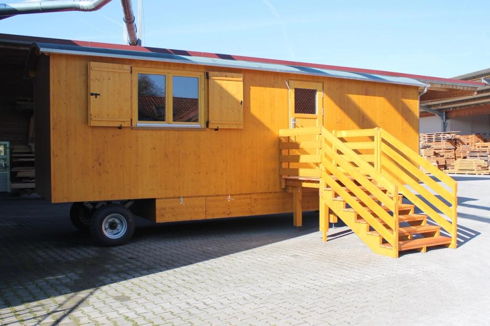 Honigfarbener Waldkindergartenwagen von der Seite mit Fensterläden, Tür und breiter Treppe