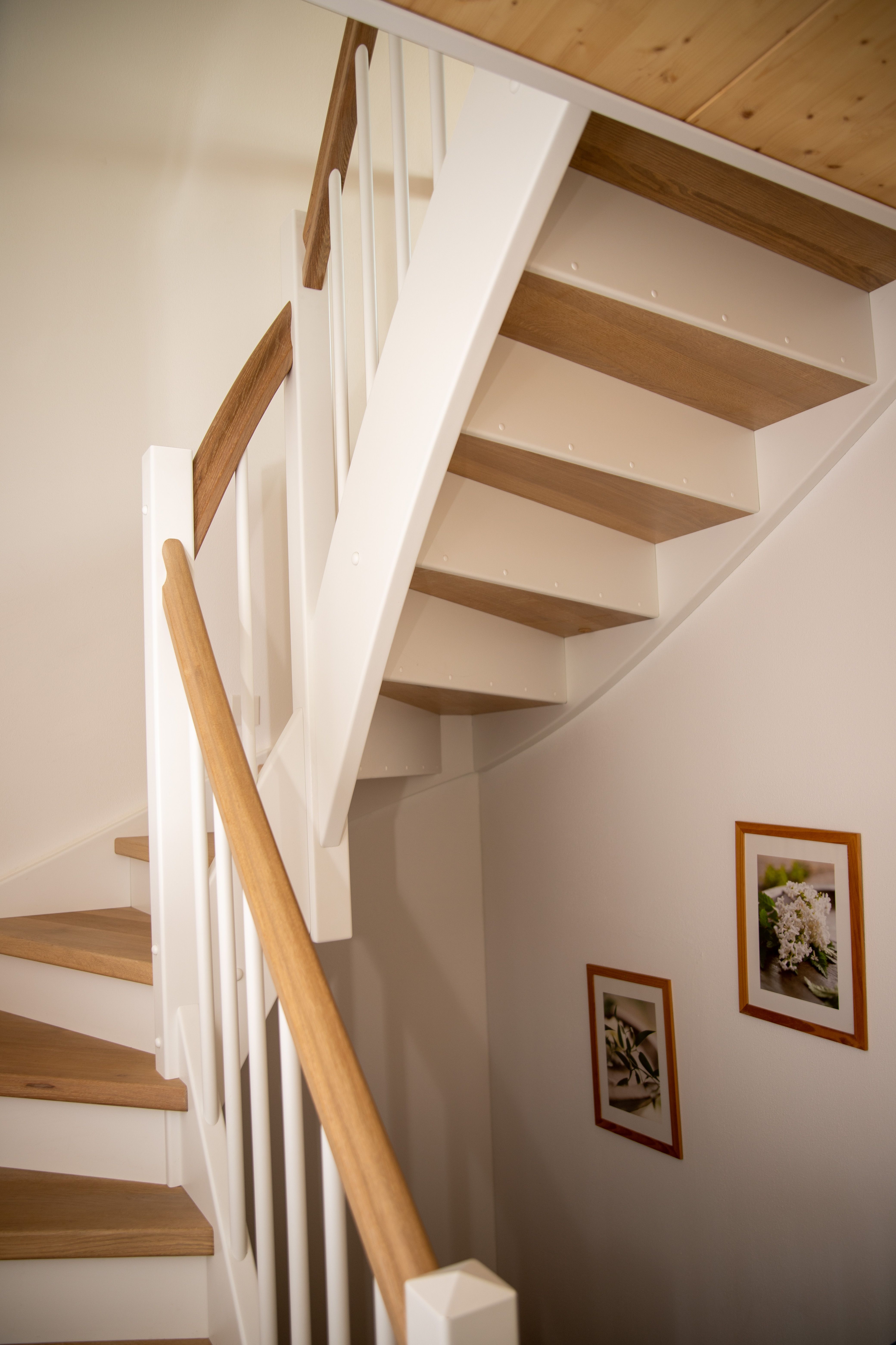 Untersicht der gewendelten Treppe mit Eichenstufen und Bilderrahmen