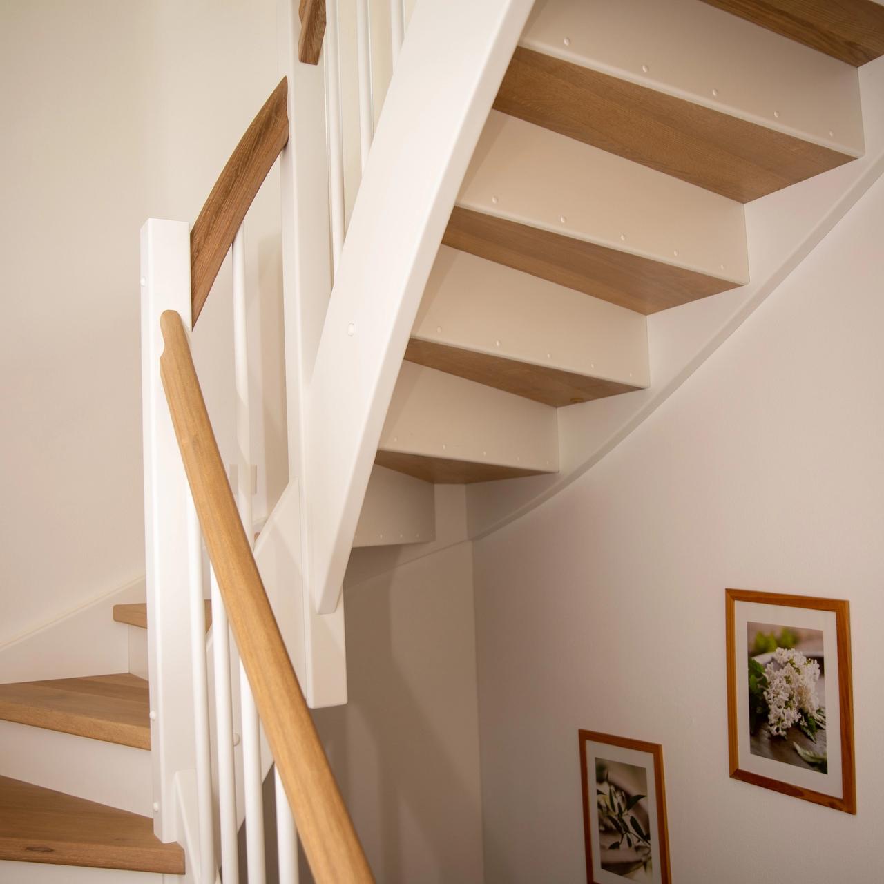 Untersicht der gewendelten Treppe mit Eichenstufen und Bilderrahmen