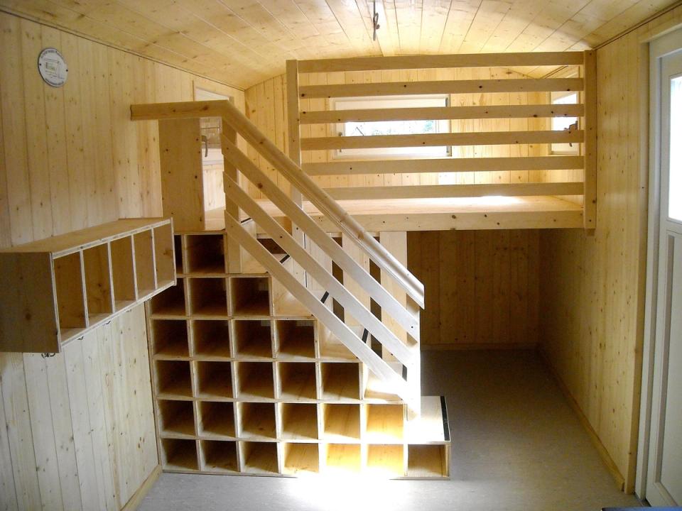 Treppe mit Fächern für Taschen und Schuhe hinauf zur Hochebene im Waldkindergartenwagen