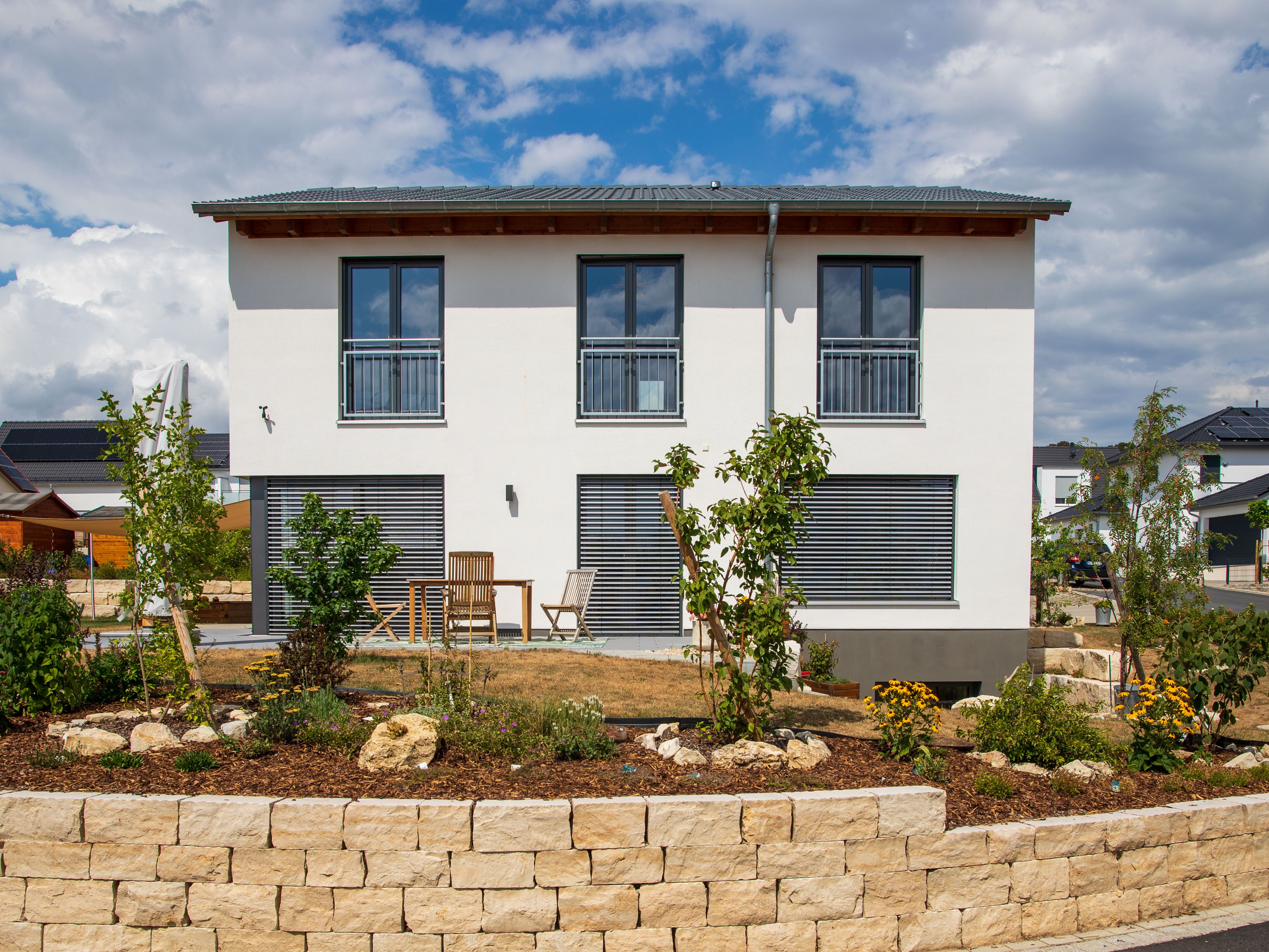 Rückansicht mit Terrasse und Natursteinmauer