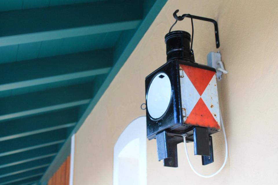 Alte Bahnhofslaterne unter dem grünen Vordach