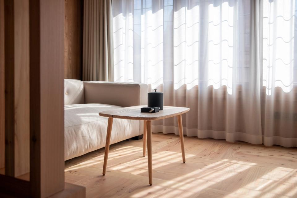 Helles Sofa und Beistelltisch im Sonnenlicht des Altbau-Hotelzimmers