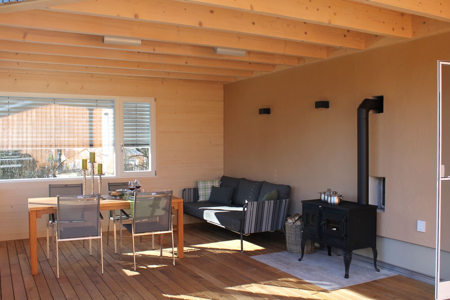 Überdachte Terrasse der Eiche mit Lounge, Essbereich und Kaminofen