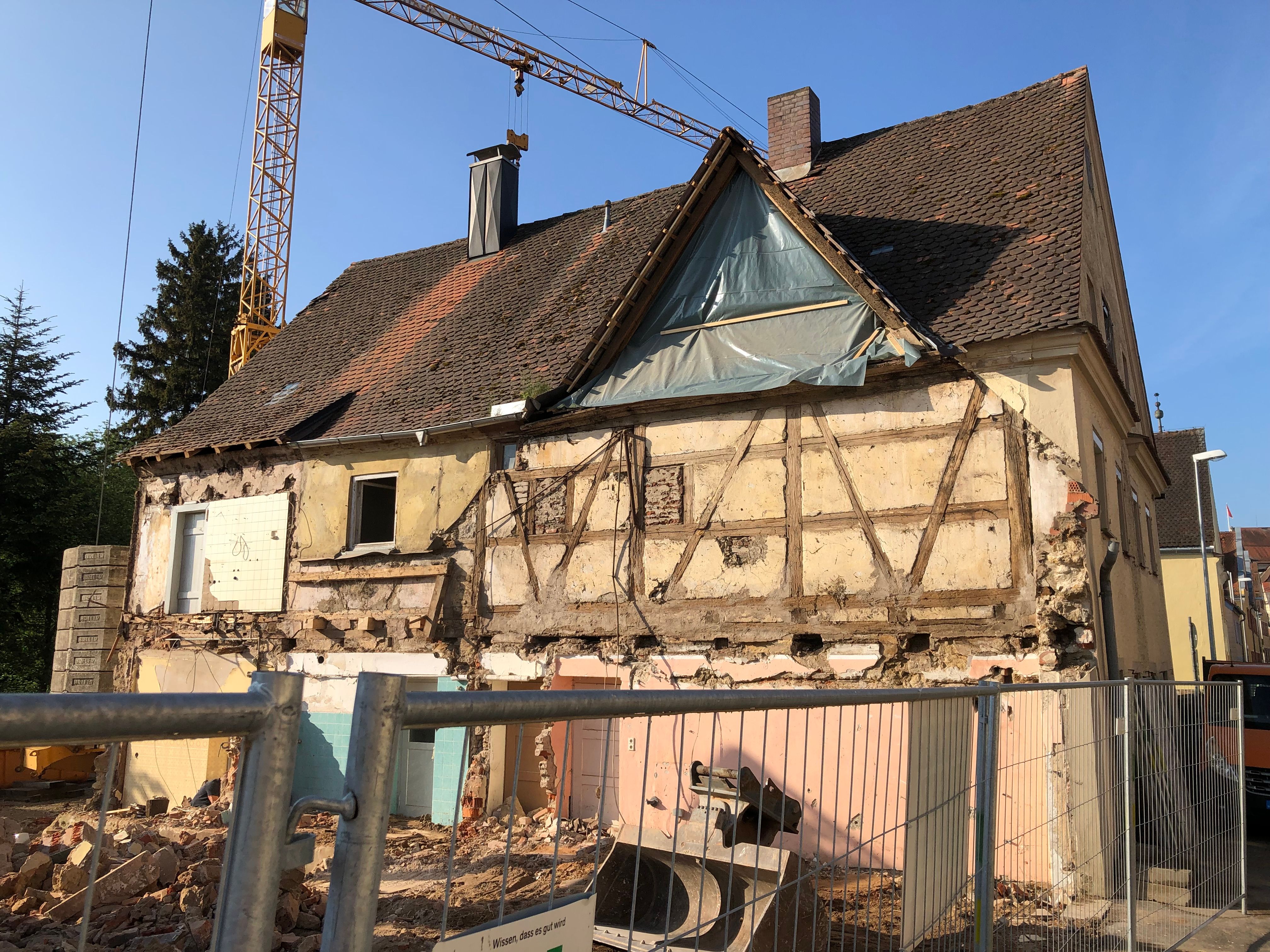 Teilabriss eines Fachwerkhauses mit freigelegtem Gebälk und Baukran