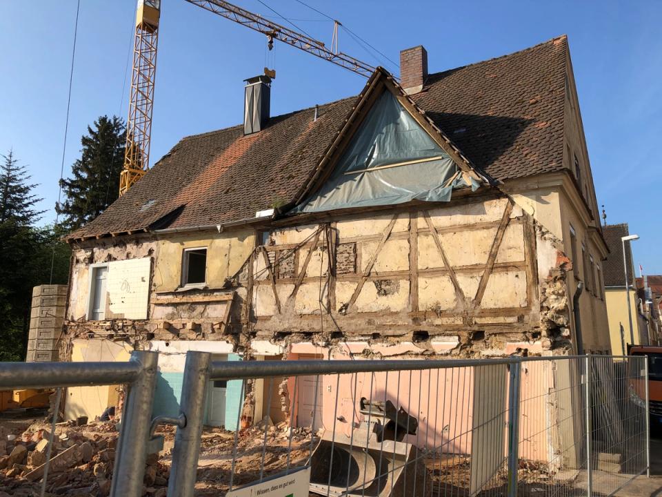 Teilabriss eines Fachwerkhauses mit freigelegtem Gebälk und Baukran