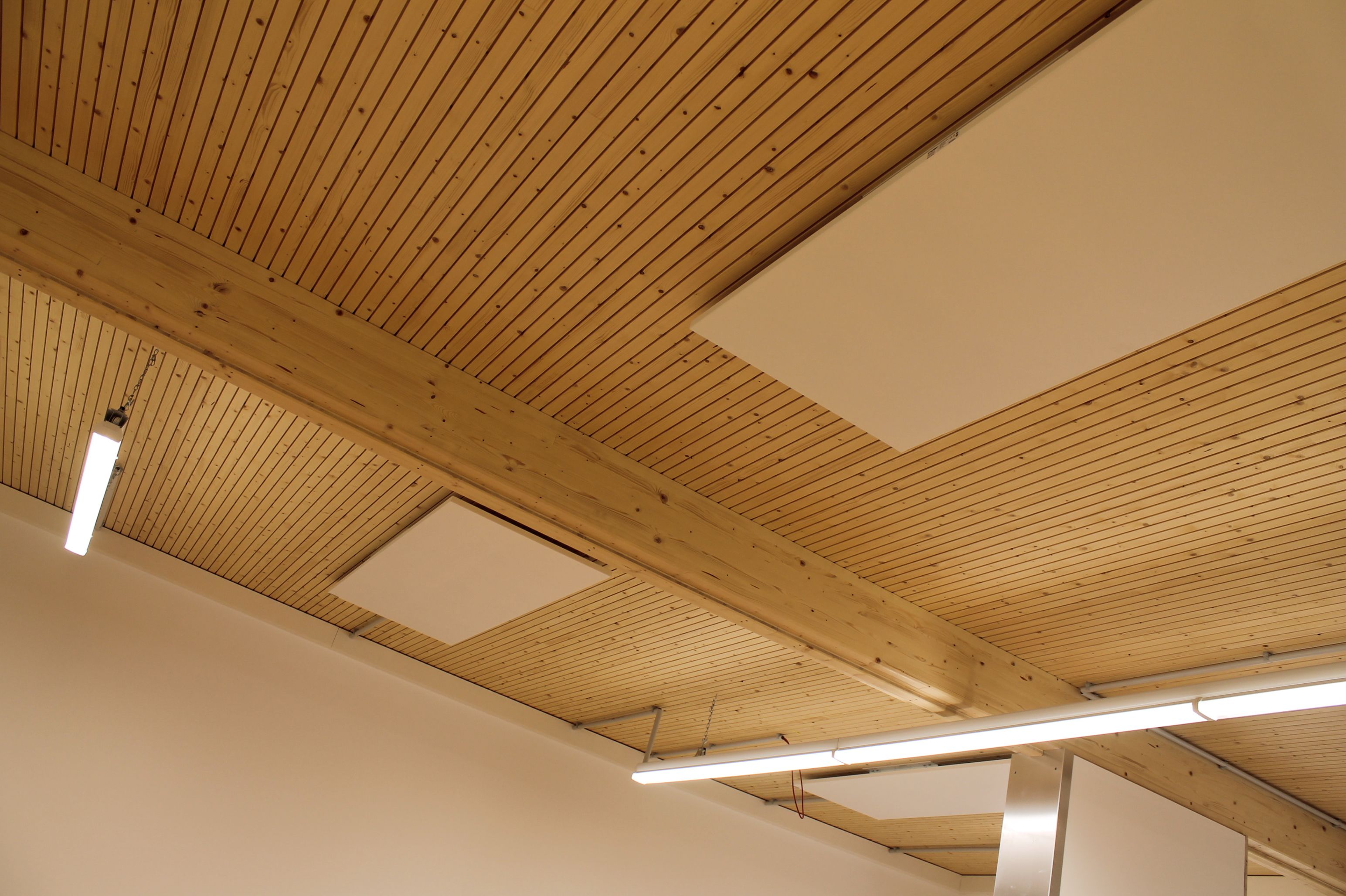 Werkstattdecke aus Holz mit Akustikpaneelen und Leuchten