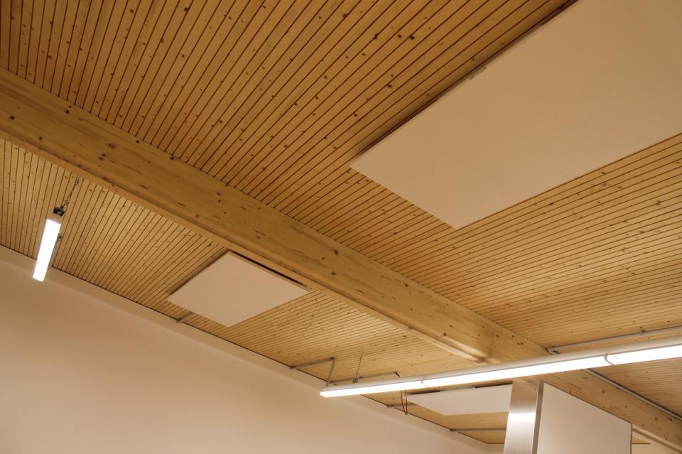 Werkstattdecke aus Holz mit Akustikpaneelen und Leuchten