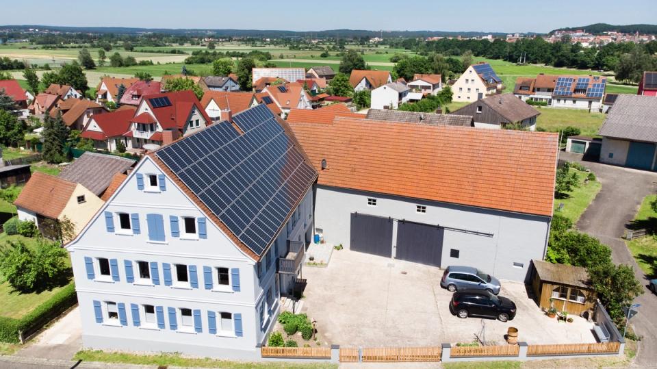 Luftaufnahme des sanierten Wohnhauses mit Scheune und Solardach