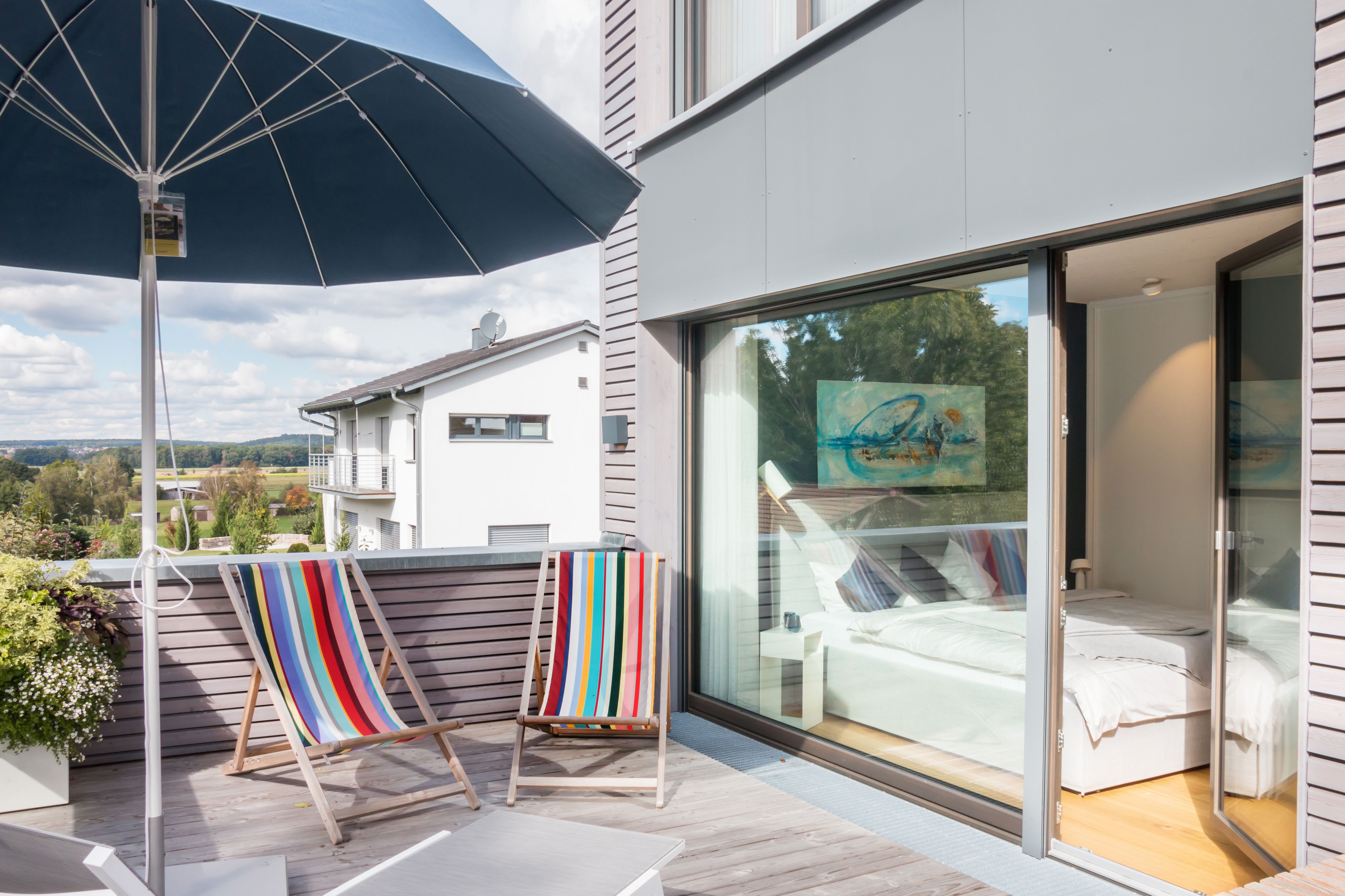 Dachterrasse des Musterhauses 2inEins mit bunten Liegestühlen