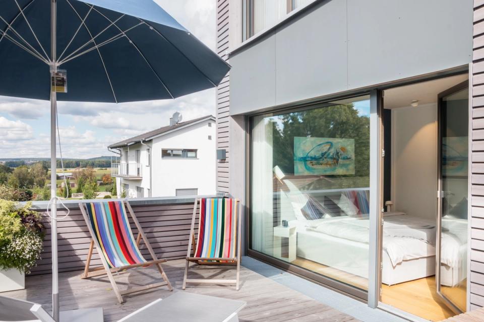 Dachterrasse mit bunten Liegestühlen und Blick ins Schlafzimmer