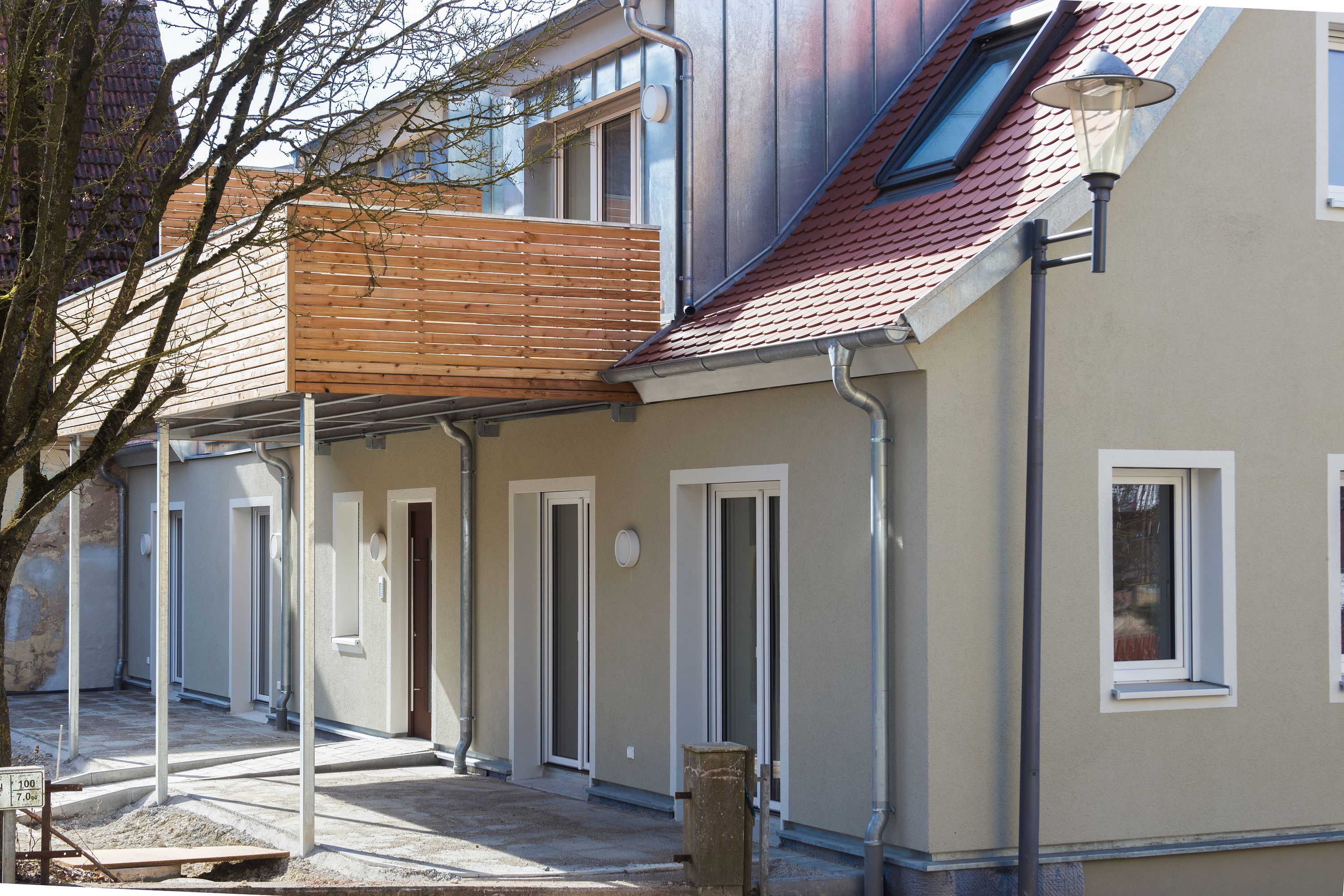 Innenhofseite mit Holzbalkon, Vordach und Zinkgaube am sanierten Haus