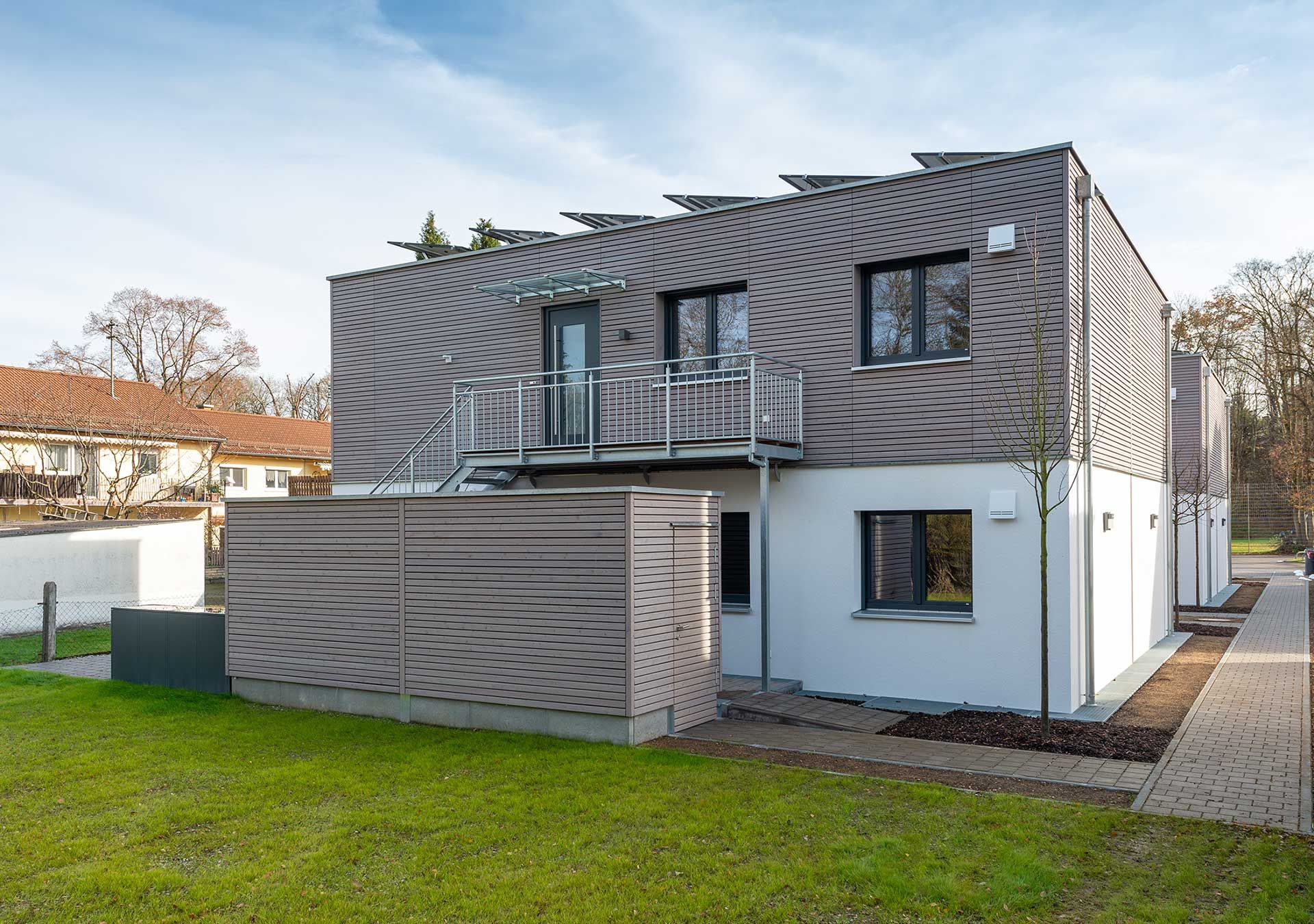 Zweigeschossiger Modulbau mit Holzfassade, Balkon und Photovoltaik