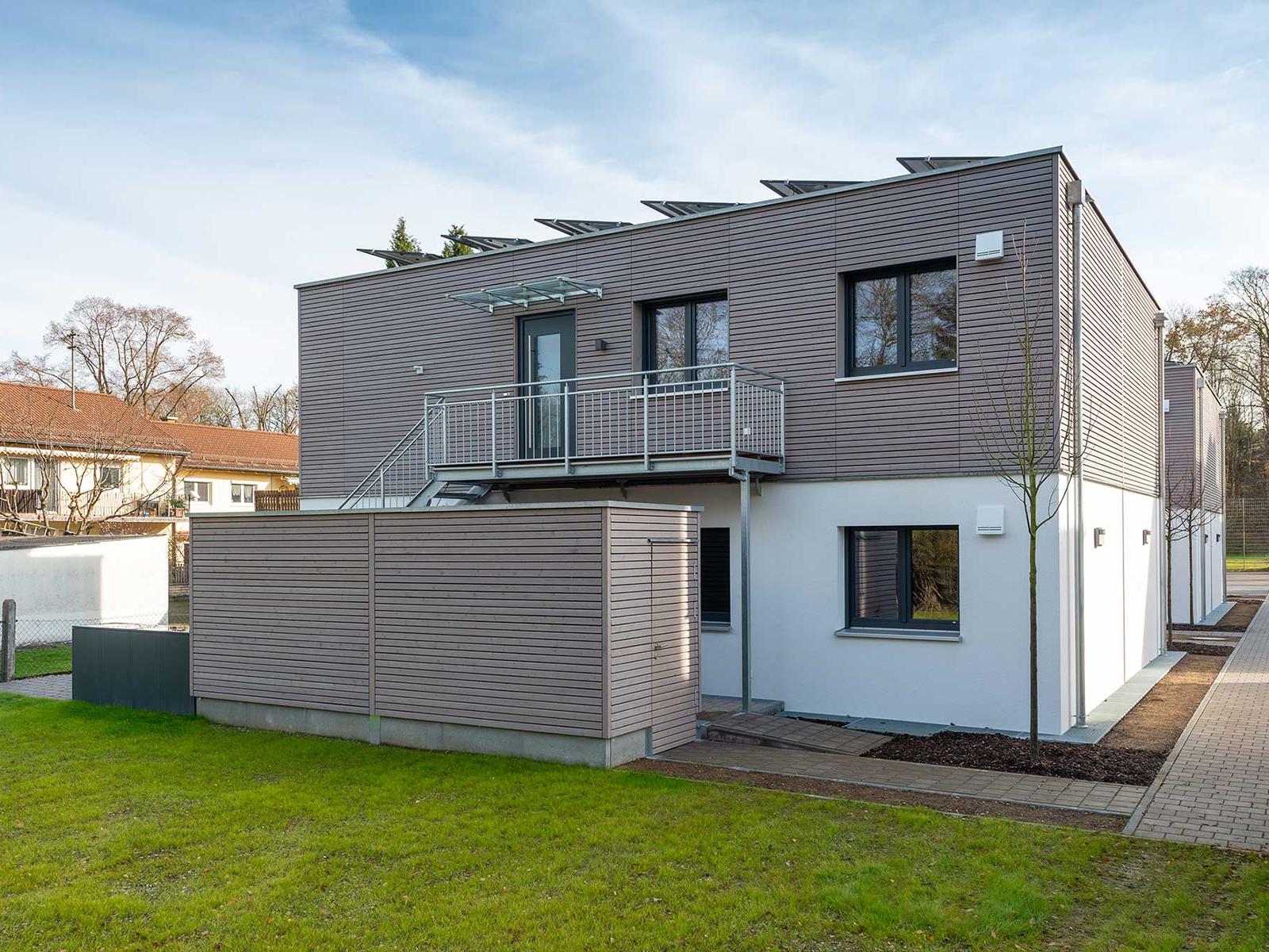 Zweigeschossiger Modulbau mit Holzfassade, Balkon und Photovoltaik