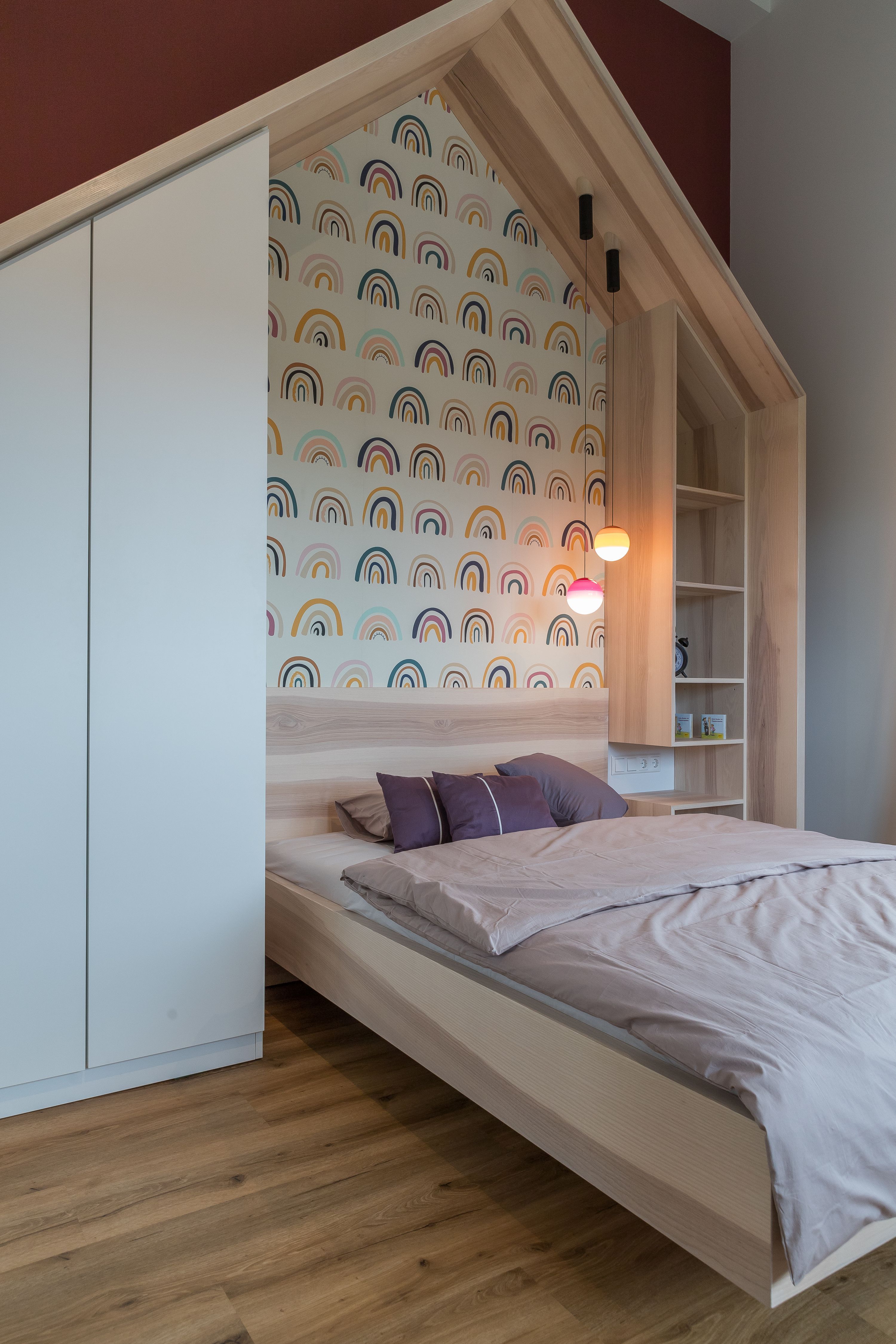 Kinderzimmer mit Hausbett und bunter Regenbogen-Tapete